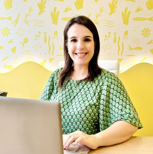Dra. Priscila Heilbrun sorrindo em seu consultório na Bem