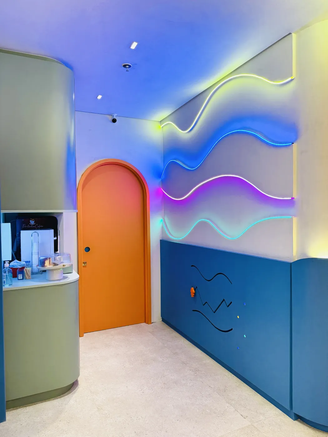 Corredor com ondas de luz neon coloridas e porta laranja em arco